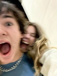 two young women are screaming while one woman is holding her head in front of the other