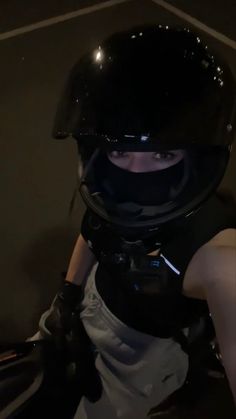 a person wearing a helmet and holding onto a motorcycle