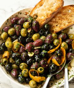 a white bowl filled with olives and bread