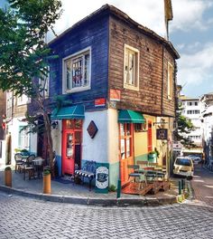 an old building with colorful doors and windows on the street in front of some parked cars