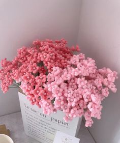 pink flowers are in a white box on the floor