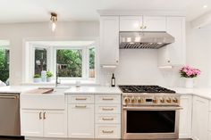 a kitchen with an oven, dishwasher, and window in the middle of it