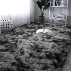 an open book sitting on top of a shaggy rug next to a potted plant