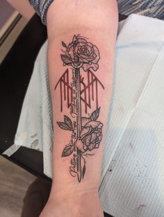 a woman's arm with a rose and dagger tattoo on the left inner forearm