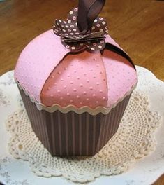 a pink cupcake sitting on top of a white plate