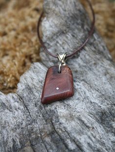 Adorned with sterling silver inlays, this outstanding and unique hand-carved 6000 year old Irish Bog Yew pendant has been made for you, or a loved one, in my studio on the West of Ireland. Bog Yew comes from ancient forests that once covered Ireland. Huge Yew trees have been buried in peat bogs and preserved from decay by the acidic and anaerobic bog conditions, sometimes for hundreds or even thousands of years. The wood is usually stained brown by tannin dissolved in the acidic water. Bog-wood represents the early stages in the fossilization of wood, with further stages ultimately forming lignite and coal over a period of many millions of years. Considered one of the Sacred trees in the Celtic world, the Yew has long been associated with immortality & longevity. As a consequence, warriors Handmade Artisan Mahogany Jewelry, Artisan Handmade Mahogany Jewelry, Artisan Wooden Jewelry As A Gift, Artisan Wood Jewelry Gift, Unique Natural Wood Pendant Jewelry, Unique Mahogany Jewelry For Gift, Artisan Brown Inlay Jewelry, Nature-inspired Wooden Pendant Jewelry, Spiritual Wood Jewelry For Gifts