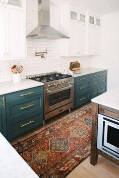 a kitchen with green cabinets and an area rug on the floor in front of the stove