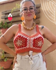 a woman wearing glasses and a crocheted crop top