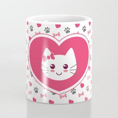 a pink heart shaped coffee mug with a cat's face on it