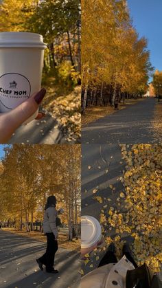 a woman holding up a cup of coffee in the middle of an autumn scene with leaves on the ground