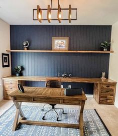 a wooden desk sitting in the middle of a living room next to a blue rug