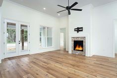 an empty living room with wood floors and a fireplace