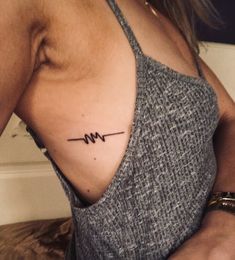 a woman with a heartbeat tattoo on her chest