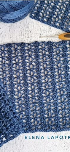 a blue crocheted scarf with a knitting needle next to it