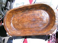 a person holding a wooden bowl in their hands