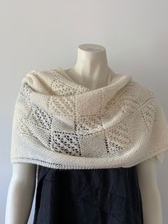 "Hand knitted shawl, which is different to the traditional triangular shawls. Here the \"wings\" are square instead of pointed. The shawl measures from point in the back to the end of a wing 125 cm. The width of a wing is 40 cm. The shawl is knitted in garter stitch combined with beautiful lace squares. The colour is offwhite. The yarn used is a lovely soft 1-ply Kidmohair and Merino wool (75/25) from Hjelholt Uldspinderi (http://www.hjelholt.dk/). The shawl is knitted with 2 strands of this yarn. Hand wash at 30 degrees with mild soap. Press all water out in a towel, lay the shawl out flat and it will be dry in a day." Cream Hand Knitted Shawl For Winter, White Hand-knitted Winter Shawl, White Hand Knitted Shawl For Winter, White Hand Knitted Winter Shawl, Handmade Alpaca Shawl Scarf, Winter Cream Hand Knitted Shawl, Hand Knitted Alpaca Shawl, Elegant Hand Knitted Alpaca Shawl, Handmade Alpaca Shawl One Size