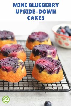 mini blueberry upside down cakes on a cooling rack with fresh berries in the background