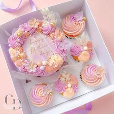 a box filled with cupcakes covered in pink frosting and topped with flowers