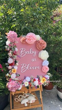 a baby in bloom sign surrounded by flowers