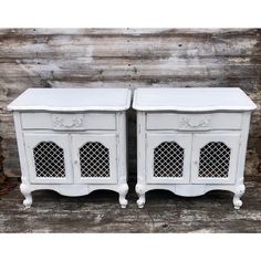 two white nightstands with latticed doors on each side and one door open to the other