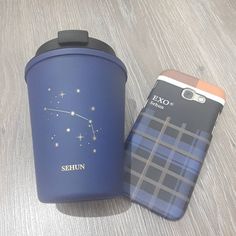 a blue travel mug next to a phone case