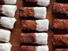 chocolate brownies with white icing on a cutting board