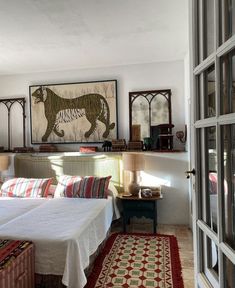 a bedroom with two beds and paintings on the wall