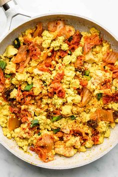 a skillet filled with scrambled eggs and vegetables