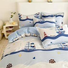 a bed with blue and white bedspread, pillows and comforter