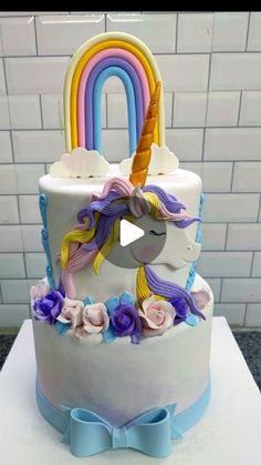 a unicorn cake with flowers and a rainbow on top