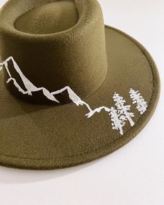 Adjustable olive green hat with mountain range painted on the brim. Green Fedora With Flat Brim For Outdoor, Olive Green Hat, Green Hat, Green Hats, Mountain Range, Ring Necklace, Ring Earrings, Decorative Accessories, Necklaces Bracelets