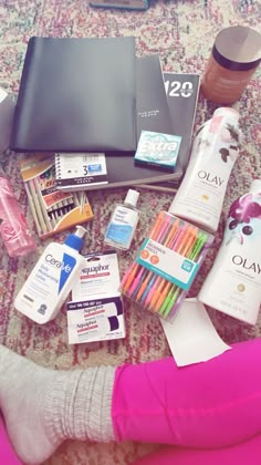 the contents of a woman's personal care kit are laid out on a carpet