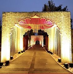 an entrance to a wedding venue decorated with flowers and lights