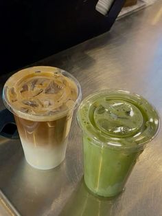 two drinks sitting on top of a metal counter