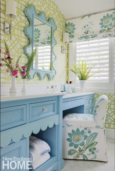 a bathroom with blue vanity and green wallpaper