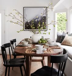 a dining room table with plates and bowls on it