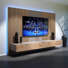 a large flat screen tv sitting on top of a wooden entertainment center