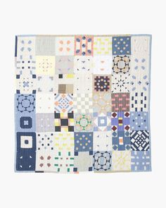 a multicolored patchwork quilt on a white background with blue and yellow squares