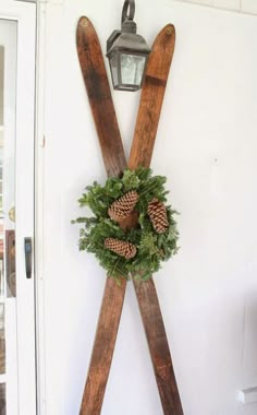 a pair of skis mounted to the side of a wall with a wreath on it