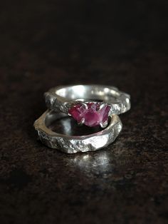 A unique ring with an uncut ruby complete with a sterling silver band. A unique ring with a unique stone - a raw ruby from Tanzania. The stone has an irregular shape and a dark pink color. Here and there you can see metallic inclusions of rutile, which makes this stone even more original. The approximate dimensions of the stone are 7 x 11 mm. The set includes a sterling silve ring with a texture matching the ring band, reminiscent of the raw texture of a rock. I designed the ring in such a way t Hand Forged Ruby Ring In Red, Hand Forged Ruby Ring Jewelry, Hand Forged Red Ruby Ring, Sterling Silver Wedding Rings With Raw Stone, Wedding Rings With Raw Stone In Sterling Silver, Hand Forged Sterling Silver Ruby Ring, Silver Ruby Birthstone Promise Ring, Anniversary Ruby Rings Hand Forged, Anniversary Hand Forged Ruby Rings