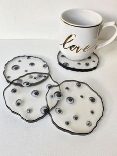 four coasters with black and white designs next to a coffee cup that says love