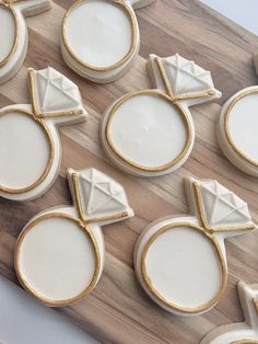 decorated cookies with gold trim and white frosting on a wooden cutting board, ready to be cut into pieces