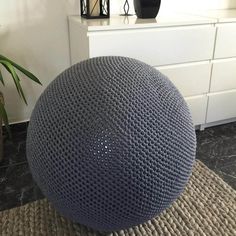 a large blue ball sitting on top of a rug next to a white dresser and potted plant