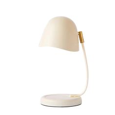 a white table lamp with a gold handle on the end and a white base, against a white background