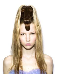 a woman with long blonde hair and a brown cow's head on her head