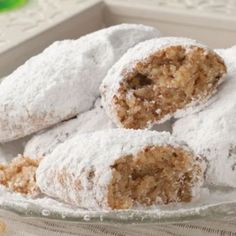 powdered sugar covered pastries on a glass plate