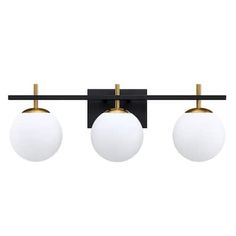 three lights on a black and gold wall mounted fixture with two white balls hanging from the ceiling