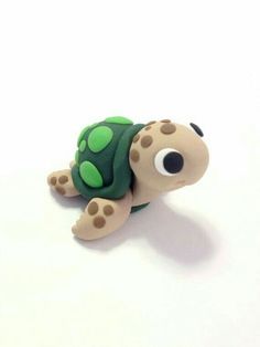 a small toy turtle sitting on top of a white surface