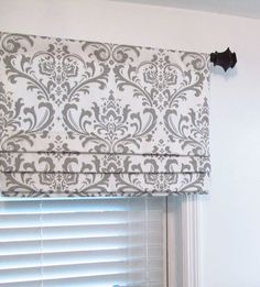 a white and gray roman blind in a bedroom