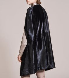 Discover the perfect blend of elegance and modernity with our cape coat, meticulously crafted from genuine Italian Horsilux in a striking jet-black hue. The short hair of the Horsilux material creates a smooth, sleek surface that enhances the coat’s sophisticated silhouette and adds a captivating shine when light hits the hair’s surface. Thoughtfully designed with two discreet pockets and a luxurious 2-way gold zipper, this coat balances practicality and style. It is lined with sumptuous 22mm Mu Cape Coat, Copenhagen Denmark, Gold Zipper, 2 Way, Jet Black, Copenhagen, Denmark, Short Hair, Fur Coat